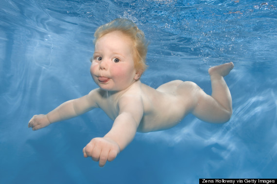 baby with a tongue out swimming underwater